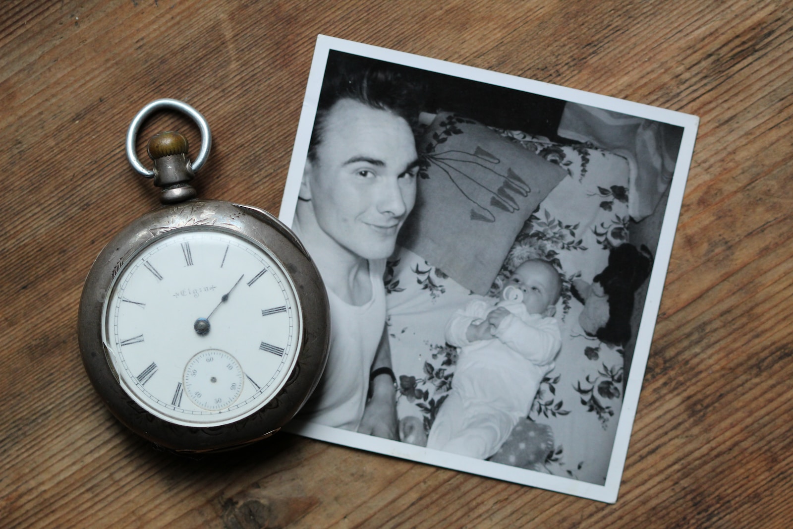 Alzheimer's, gray pocket watch beside grayscale photo of father and baby on table