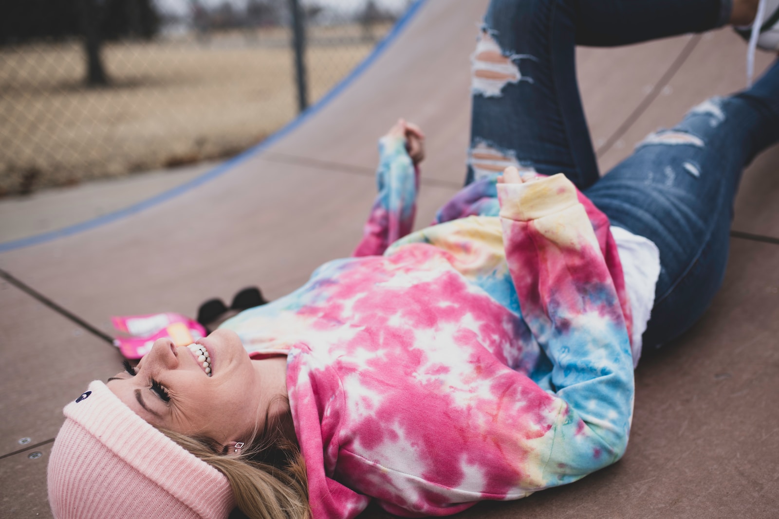 tie-dyed t-shirt girl in pink and white striped long sleeve shirt lying on ground