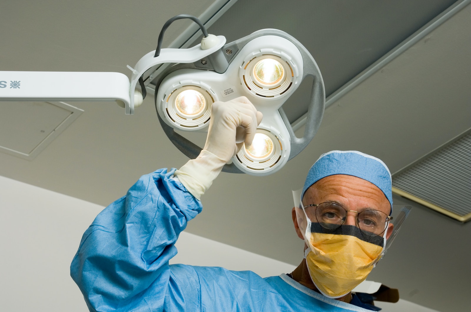 Understanding TIAs, a man in a surgical gown holding up a surgical light